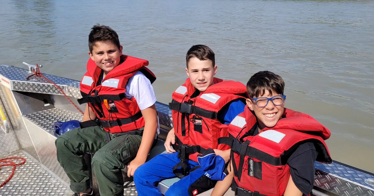 Jugendliche in Schwimmwesten auf der Zille beim Zeltlager