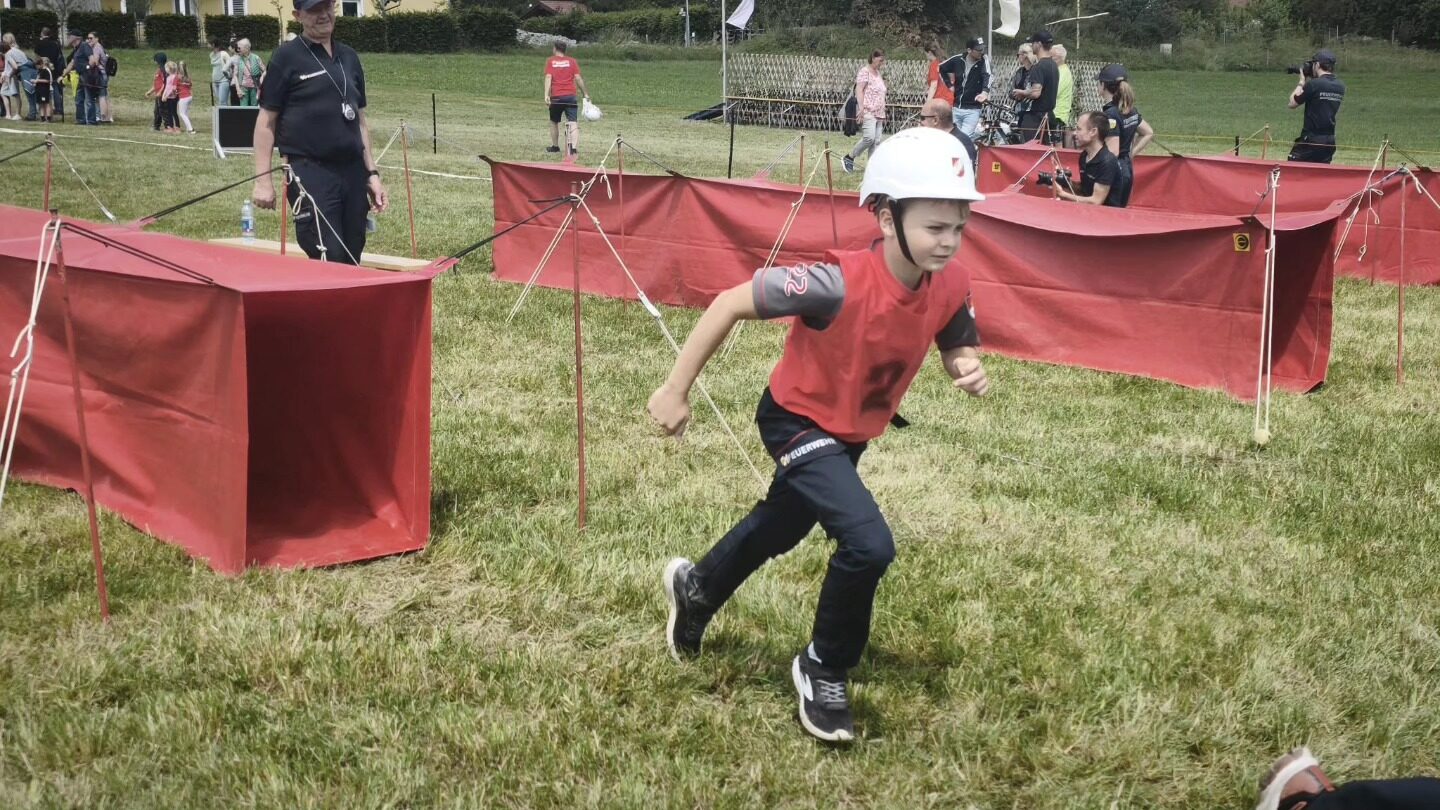 Ein Mitglied der Feuerwehrjugend sprintet beim Bewerb an den roten Sichtblenden vorbei